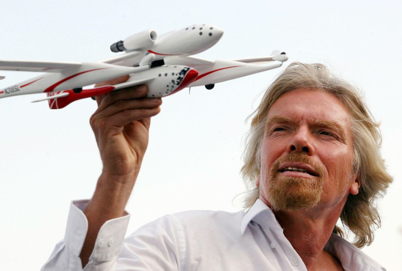 picture of sir richard branson holding a model aircraft in his right hand